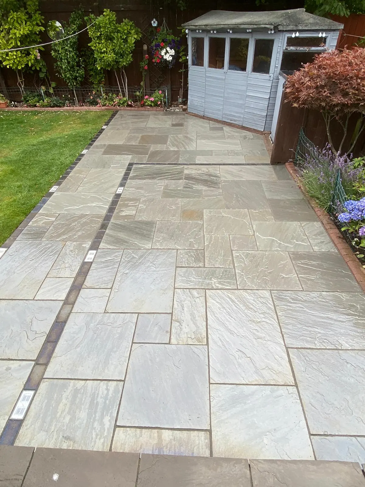 Large grey paving area with decorative borders