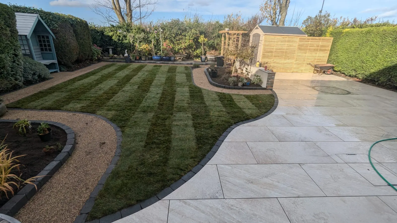 Landscaped garden with striped lawn and patio