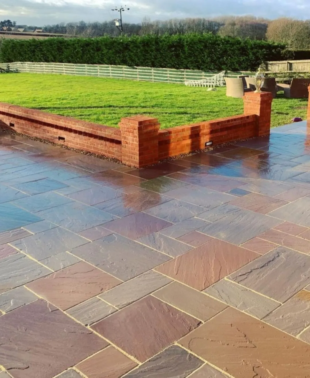 Indian sandstone patio with brick wall