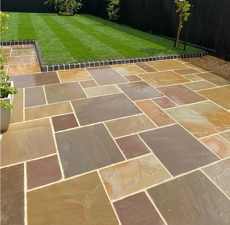 Sandstone patio with striped lawn