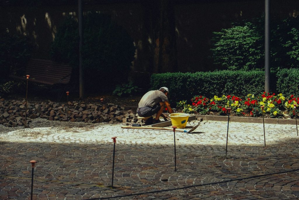 Gardener laying stones in a flower bed
